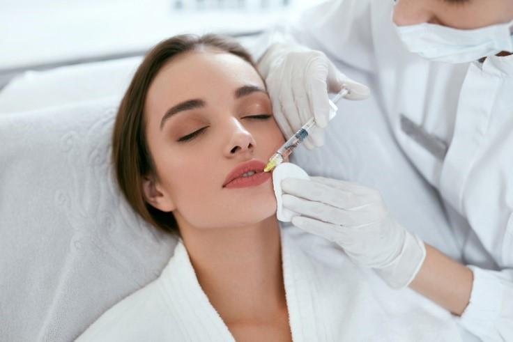 picture of a young woman receiving a perfect pout procedure, woman having lip filler treatments
