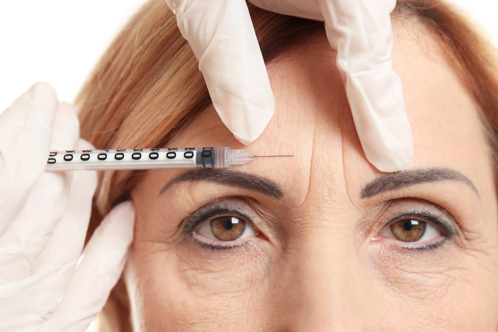 picture of Woman receiving aesthetic botox injection in forehead to reduce wrinkles